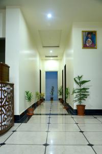 a hallway with potted plants in a building at Hotel Roselle Heights in Jaipur