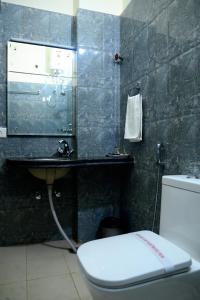 a bathroom with a sink and a toilet and a mirror at Hotel Roselle Heights in Jaipur +23 photos