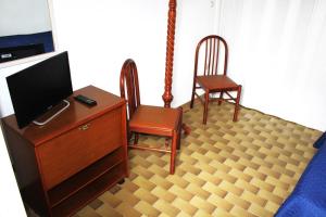 ein Wohnzimmer mit Fernseher und zwei Sesseln in der Unterkunft bilo giuggianello by salentolimit in Torre Lapillo