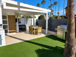 a patio with a table and a grill on a deck at Suite Coco in Maspalomas