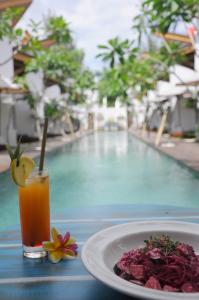 a plate of food and a drink next to a pool at Jali Resort - Gili Trawangan in Gili Trawangan