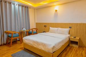 a bedroom with a bed and a table and chairs at Shikali Resort in Pātan +58 photos