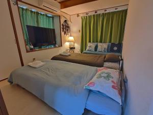 a bedroom with two beds and a large window at Green Hights Residence-101 in Naha