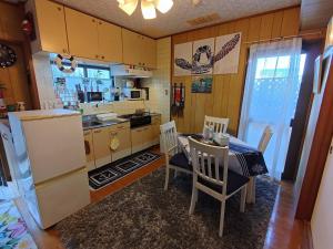a kitchen with a table and chairs and a refrigerator at Green Hights Residence-101 in Naha