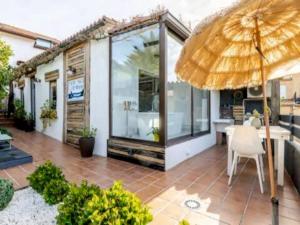 a patio with an umbrella and a table and chairs at Mar no Camiño. Terraza, bañera con vista al mar. in Brens
