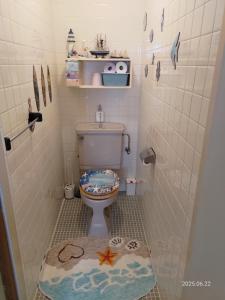 a bathroom with a toilet and a rug on the floor at Green Hights Residence-101 in Naha +25 photos