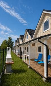 a row of houses with blue chairs on a deck at Domki 7 Houses Rewal in Rewal