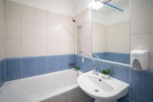 a bathroom with a sink and a tub and a toilet at Comfort 28 - Great Value Apartment with Full Kitchen in Miskolc