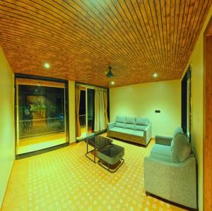 a living room with two couches and a table at Hotel Nakshtra Residency in Bramhapuri