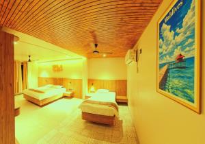 a bedroom with two beds and a painting on the wall at Hotel Nakshtra Residency in Bramhapuri