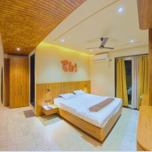 a bedroom with a large bed and a ceiling at Hotel Nakshtra Residency in Bramhapuri