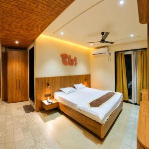 a bedroom with a large bed and a ceiling at Hotel Nakshtra Residency in Bramhapuri