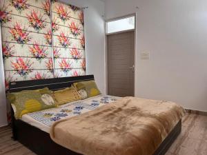 a bedroom with a large bed with a floral wall at royal palace and resort in Sultānpur