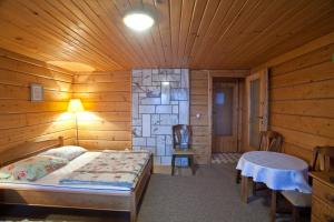 een slaapkamer met een bed in een houten kamer bij Janosik in Kluszkowce