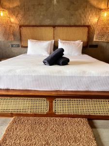 a bed with white sheets and two pairs of jeans on it at Roys Villa Sigiriya in Sigiriya +12 photos