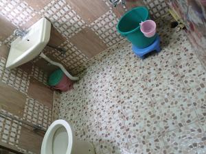 a bathroom with a toilet and buckets on the floor at Aziz Guest House Near dal lake in Srinagar
