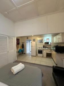 a large room with a bed and a kitchen at Manly Beach Studio in Sydney