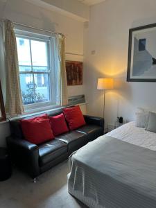a bedroom with a bed and a couch and a window at Manly Beach Studio in Sydney