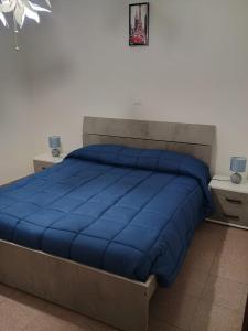 a blue bed in a bedroom with two night stands at I Trecento in Padula