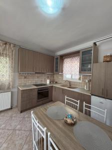 a kitchen with a wooden table and chairs and a kitchen with a counter at Crystal seaview home in Iraklitsa