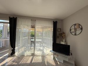 a living room with a tv and a balcony at Crystal seaview home in Iraklitsa