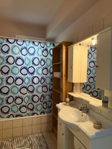 a bathroom with a sink and a shower curtain at Crystal seaview home in Iraklitsa +8 photos