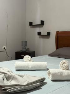 a bedroom with two beds with white sheets and towels at Crystal seaview home in Iraklitsa