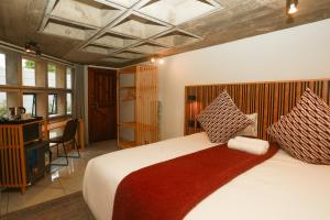 a bedroom with a large bed with a red blanket at Asali Lodge in East London +243 photos