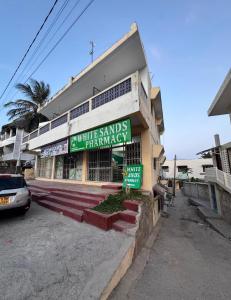 a building with a sign that reads white sands pharmacy at nova nest in Watamu