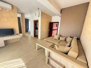 a living room with a couch and a television at Hotel Dabi Imperial in Donji Štoj