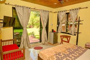 a bedroom with a bed and a large window at The Rippling Edge - River front property in Karjat