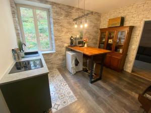 a kitchen with a wooden table in a room at Cocon romantique Jardin de la princesse idéal couple Calme & nature Vosges in Senones