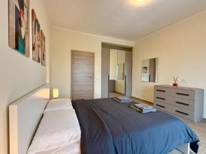 a bedroom with a large bed and a dresser at SNG - Paggi 78 in Vercelli
