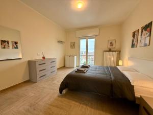 a bedroom with a bed and a dresser and a window at SNG - Paggi 78 in Vercelli