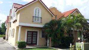 ein Haus mit Palmen davor in der Unterkunft 3 Springcourt Apartment in Bridgetown