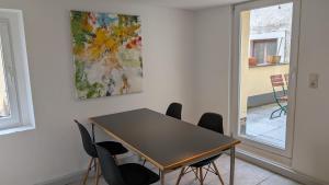 a table and chairs in a room with a painting at Ferienhaus am Main in Veitshöchheim +18 photos