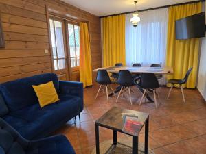 a living room with a blue couch and a table at Dolina Biebrzy - Chata Retmana in Wroceń