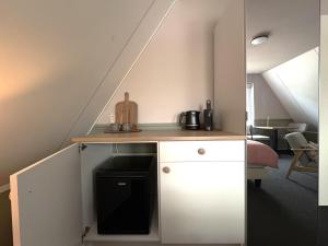 a small kitchen with a counter in a attic at B&B Wetterwille in Opeinde