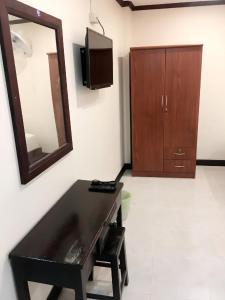 a room with a desk and a mirror and a cabinet at Memory Hotel in Vientiane