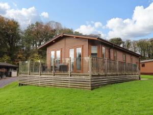 a small cabin on a grassy field with a house at Lakeview Lodge in Preston