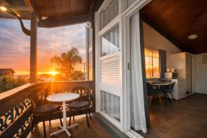 a balcony with a table and chairs and a large window at Jetty Motel The Entrance in The Entrance