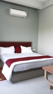 a bedroom with a large bed with a red blanket at S&J Hotel & Banquet in Bhabua