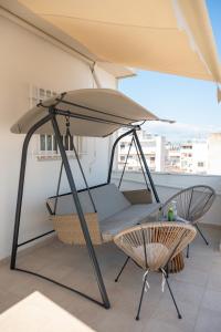 a swing on a balcony with an umbrella at Bill Apartments in Patra