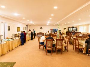 a group of people in a room with tables at Asson Hotel Termez in Termiz