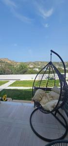 a hanging bed with pillows on a patio at Alora House 2 in Kefalos