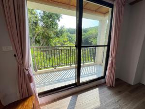 a room with a large window with a view of a balcony at Wanzai B&B in Xiaoliuqiu +32 photos