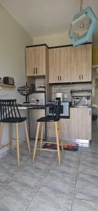 a kitchen with two chairs and a table and cabinets at Alora House 2 in Kefalos