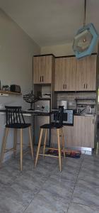 a kitchen with two chairs and a table and cabinets at Alora House 2 in Kefalos