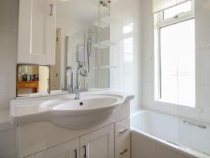 a white bathroom with a sink and a tub at 24 The Salcombe in Salcombe +28 photos