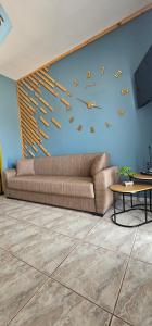 a living room with a couch and a clock on the wall at Alora House 2 in Kefalos